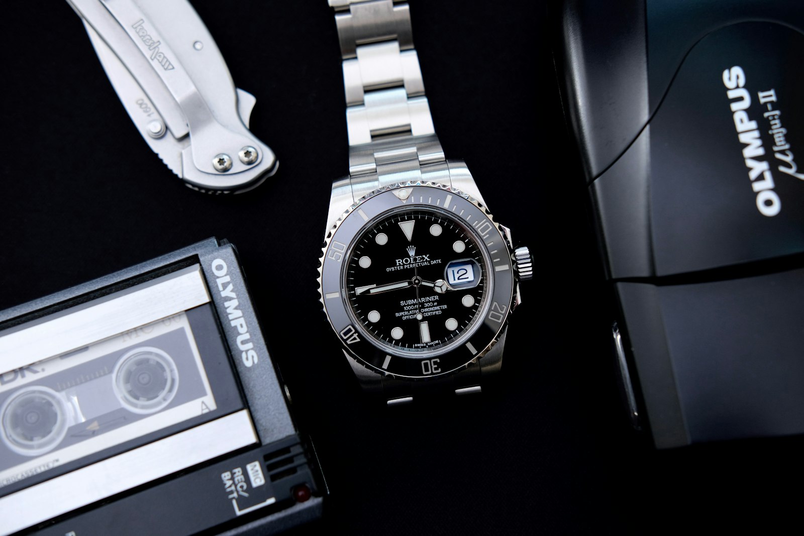 A Rolex Submariner laid flat among a collector's tools